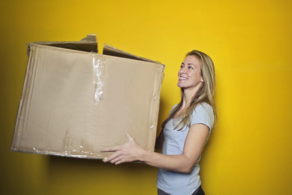 Beautiful blonde woman holding a moving box