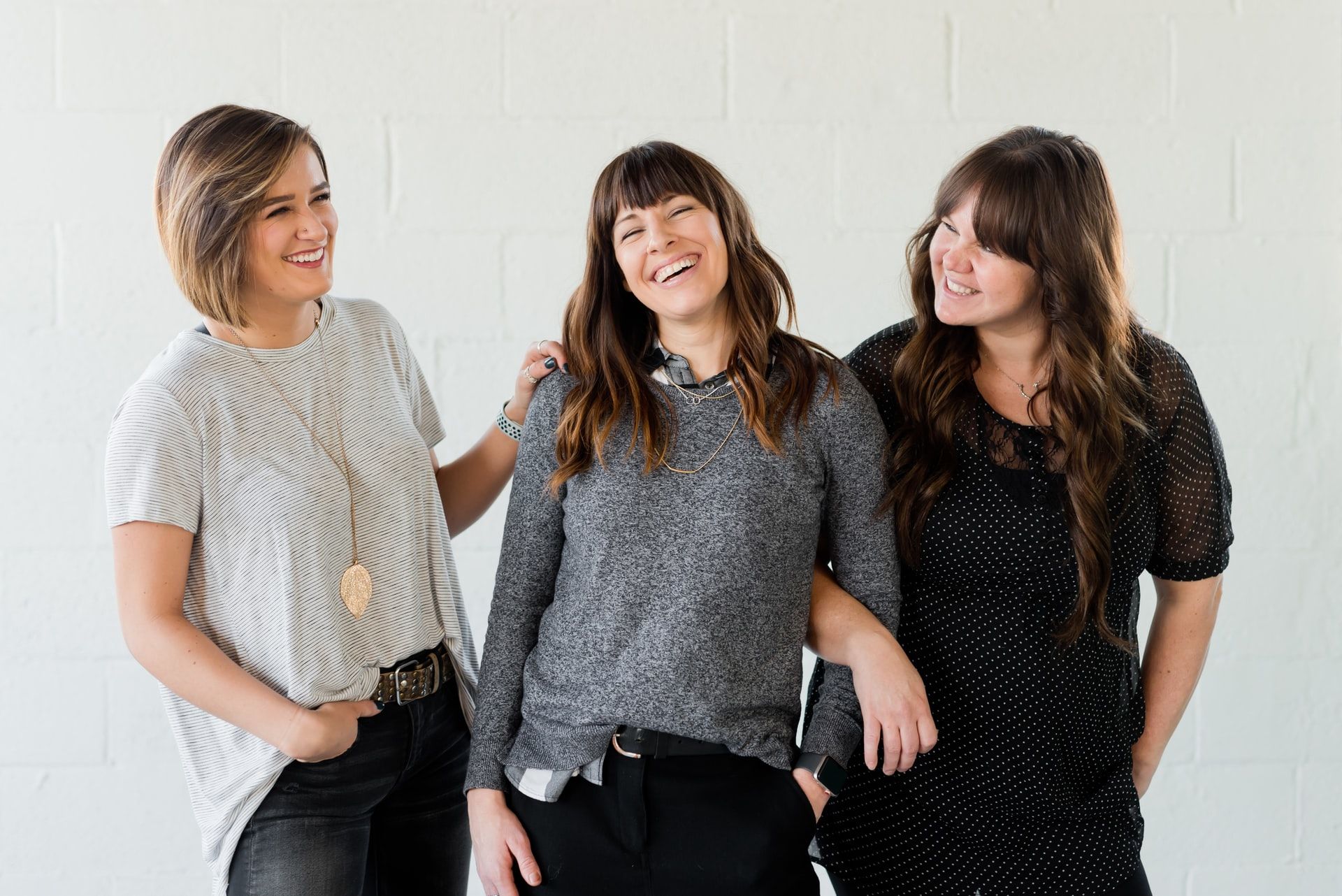 three women posing together and smiling