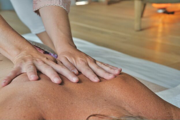 Female hands massaging a man’s back